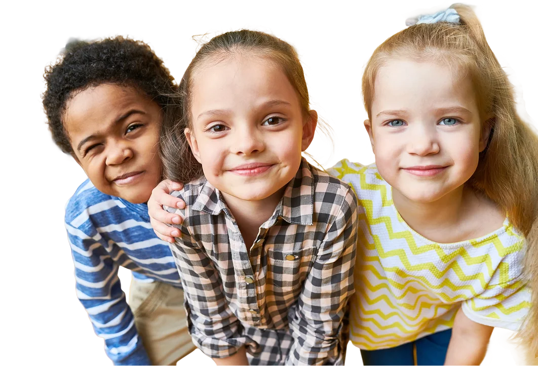 Three children smiling and hugging outdoors